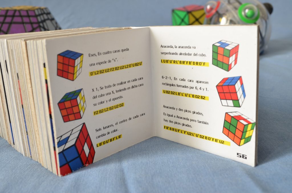 Libro mostrando diferentes algoritmos (soluciones) para el cubo rubik